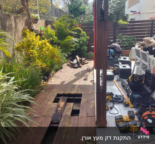 תיקון דק עץ עם כלים חשמליים בגינה